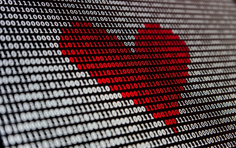 A red heart on a black and white screen background of 1s and 0s.